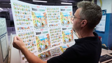 An employee inspects the print sheet