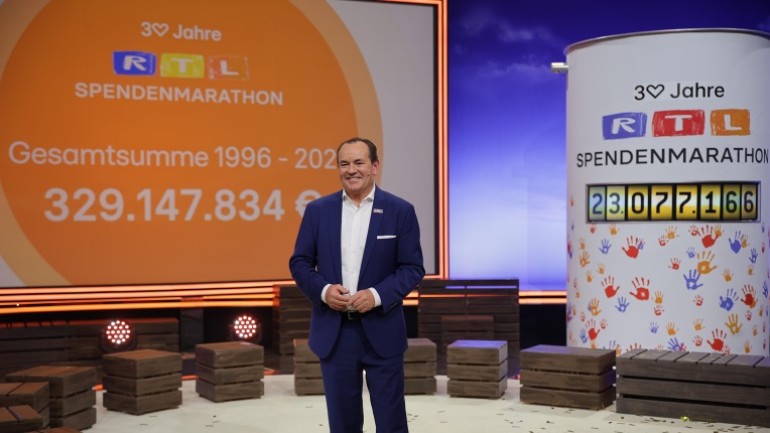 Wolfram Kons in front of the display showing the donation total for 2025