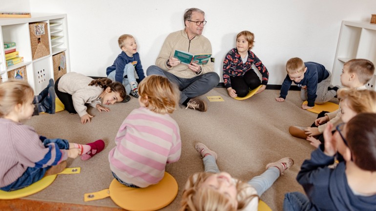 Immanuel Hermreck reading together with children