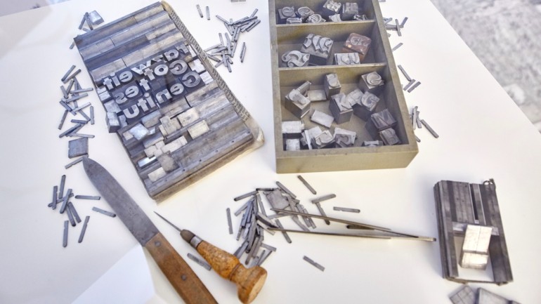 Old type case from the print shop with lead letters, types and composing stick, 1920s.
