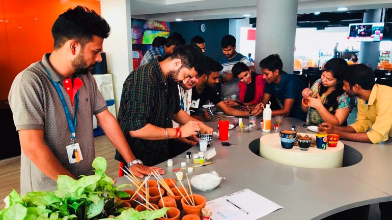 Arvato employees in Guragaon painted pots before planting trees in them